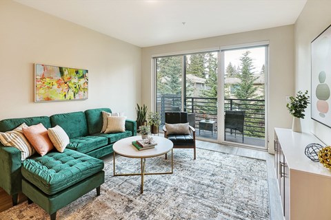 a living room with a green couch and sliding glass doors